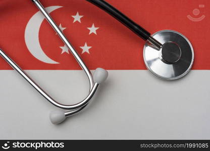 Singapore flag and stethoscope. The concept of medicine. Stethoscope on the flag as a background.. Singapore flag and stethoscope. The concept of medicine.