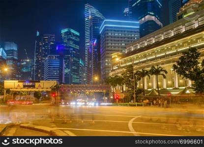 Singapore metropolis, Downtown core illuminated in night, crowd of people in motion blur crossing city highway, buildings of modern architecture in background