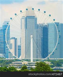 Singapore modern cityscape with skyscrapers of Downtown Core and ferris wheel in foreground