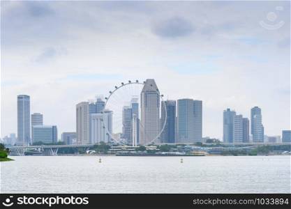 Singapore modern cityscape with skyscrapers of Downtown Core, ferris wheel and river