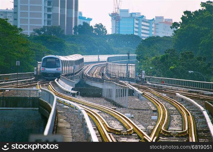 Singapore MRT train on a railroad at sunset