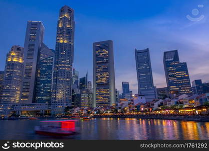 Singapore. Quay with cafes and skyscrapers. Pleasure boats. Dusk. Twilight on the Quay of Singapore with Skyscrapers