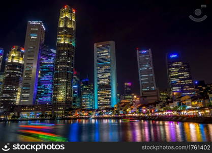 Singapore. Quay with cafes and skyscrapers. Pleasure boats. Night. Night on the Quay of Singapore with Skyscrapers
