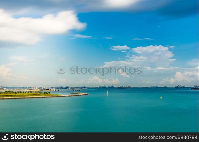 Singapore Seascape From Marina Barrage with Cargo ship at port and nice sky with sun flare