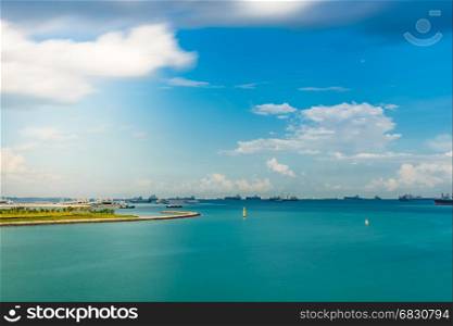 Singapore Seascape From Marina Barrage with Cargo ship at port and nice sky with sun flare