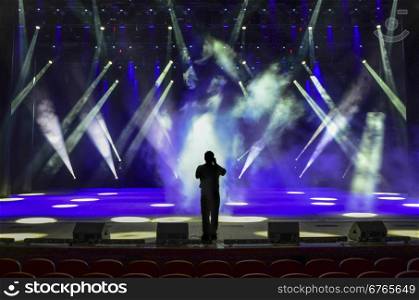 singing man silhouette on a brightly lit concert stage