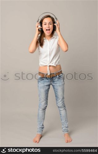 Singing teenager girl enjoy music headphones full length on grey background