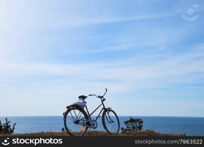 Single bike with a bath towel stands by the coast