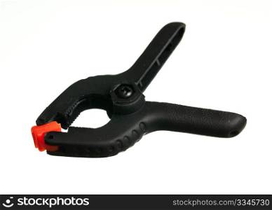 Single black spring clip with orange jaws used to hold small objects together as a clamp