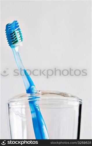 Single blue toothbrush in bathroom toothbrush holder.
