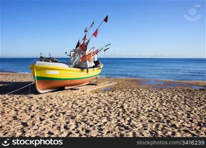 Single boat on a sandy beach at the Baltic Sea in Poland