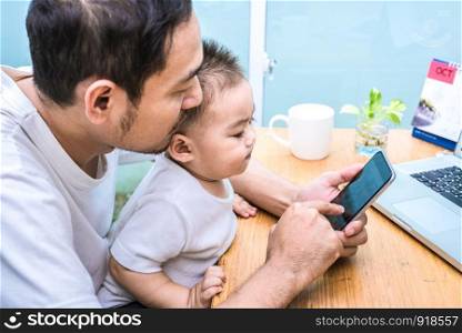 Single dad and son using laptop together happily. Technology and Lifestyles concept. Happy familly and baby theme.