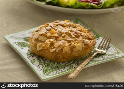 Single fresh baked traditional Moroccan small bastella with roasted almond topping