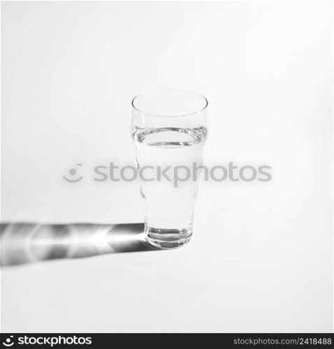 single glass water with bright shadow isolated white background