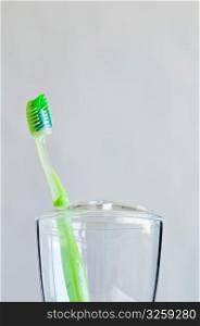 Single green toothbrush in bathroom toothbrush holder.