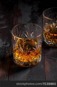 Single malt scotch whiskey in crystal glasses on wooden table background. Top view