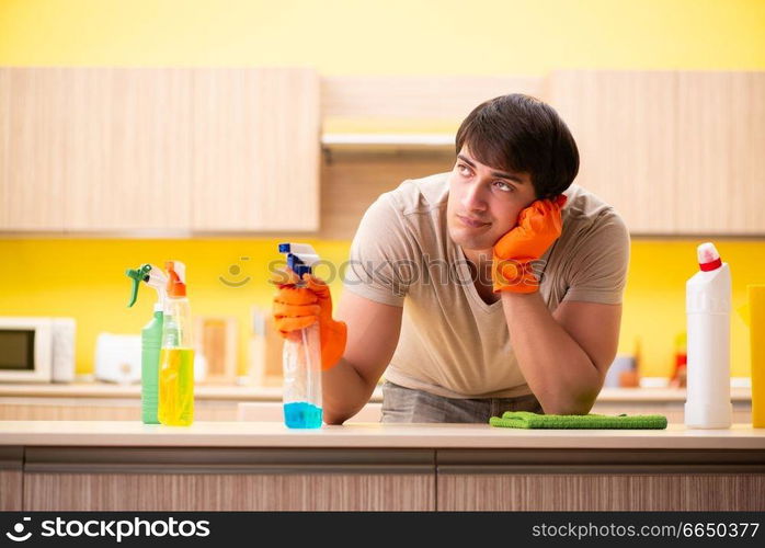 Single man cleaning kitchen at home