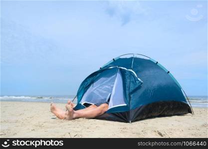 Single man sleeping in shelter at the beach