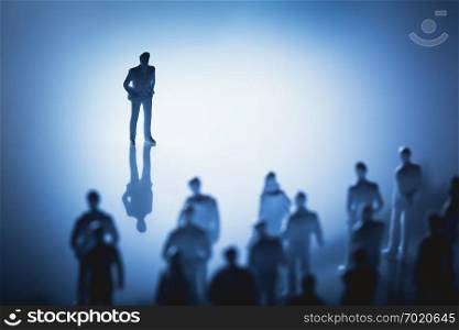Single man standing in front of group of people. Leader, influencer, guide. Figurines.. Single man standing in front of group of people.