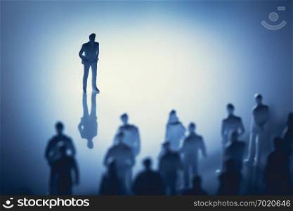 Single man standing in front of group of people. Leader, influencer, guide. Figurines.. Single man standing in front of group of people.