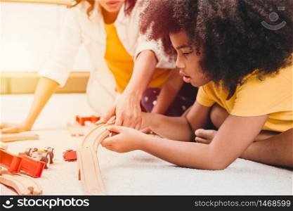 Single mom living with two daughter learning and playing puzzle toy in home apartment. Nanny looking or childcare at living room black people.