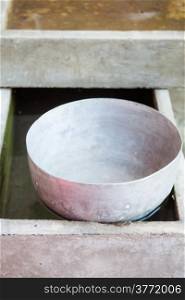 Single old stainless water bowl floating on water