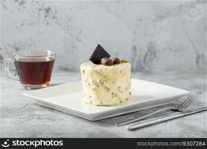 Single person mini cake with pistachio and white chocolate on a white porcelain plate
