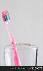 Single pink toothbrush in toothbrush holder.