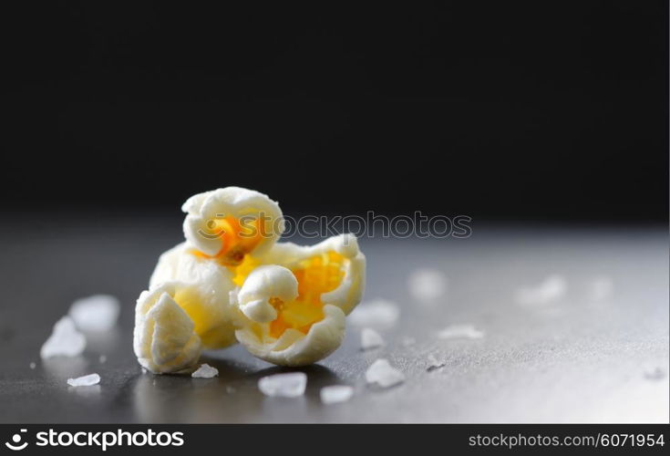 Single popcorn and salt isolated on black background