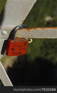 Single red love lock padlock. This is on Marys Bridge, overlooking Neuschwanstein Castle, Bavarian Alps, Germany, Europe.