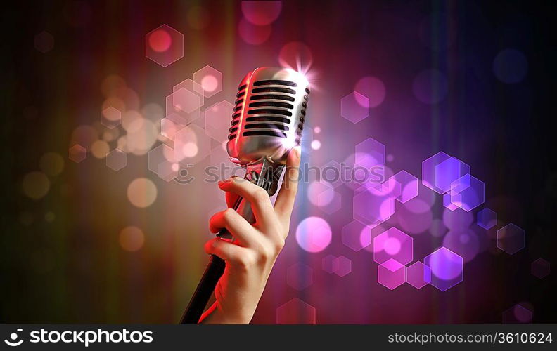 Single retro microphone against colourful background with lights