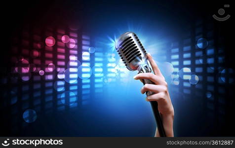 Single retro microphone against colourful background with lights