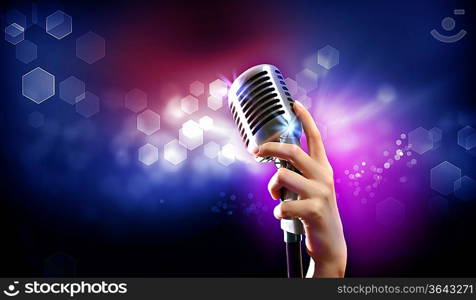 Single retro microphone against colourful background with lights