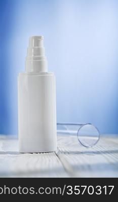 single skincare sprayer on white wooden table