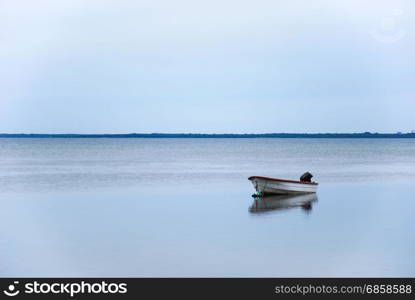 Single small boat with reflection in a calm water