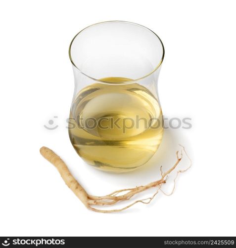 Single tea glass with Ginseng drink and ginseng root isolated on white background close up