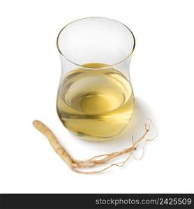 Single tea glass with Ginseng drink and ginseng root isolated on white background close up