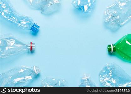 Single use plastic bottles on blue background with copy space top view. Recycle concept.