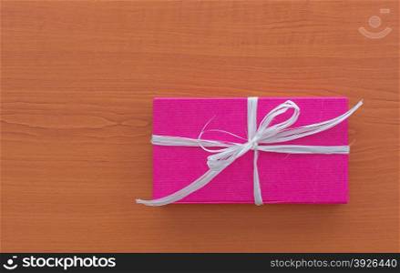 Single violet gift box with white ribbon on the table