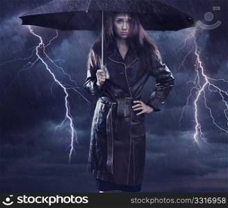 Single woman wearing coat holding umbrella. Creative szmbol of the bad weather