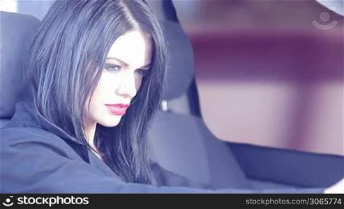 Single woman with long black hair in driver&acute;s seat of car.