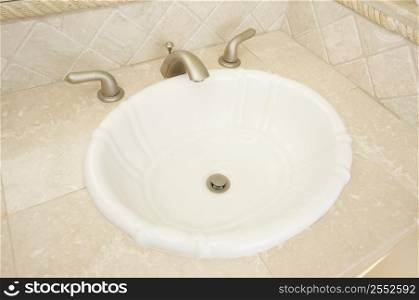Sink and tap faucet with beige tiles