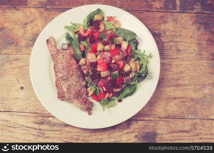 Sirloin steak and salad arranged on a white plate