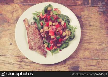 Sirloin steak and salad arranged on a white plate