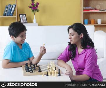 Sister and brother playing chess in living room