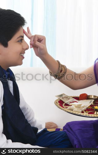 Sister applying tilak to her brother at Raksha Bandhan