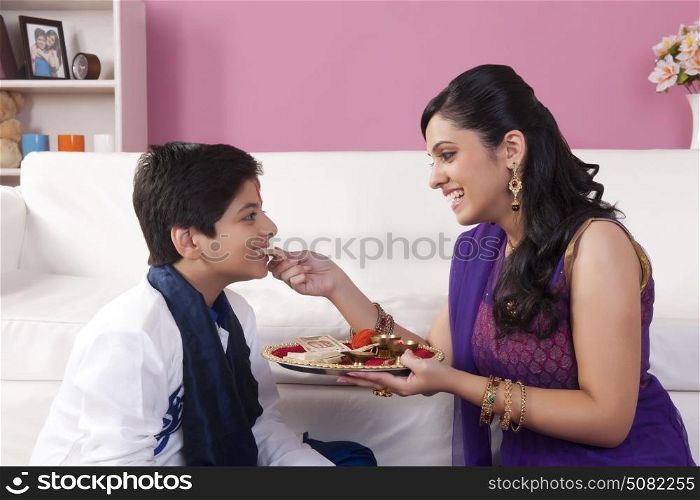 Sister feeding sweets to her brother at Bhaidooj