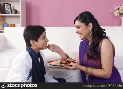 Sister feeding sweets to her brother at Bhaidooj