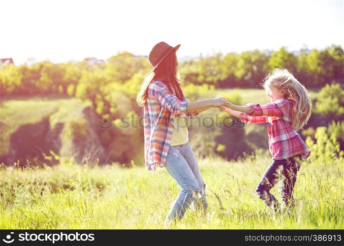 Sister girls having fun in the meadow