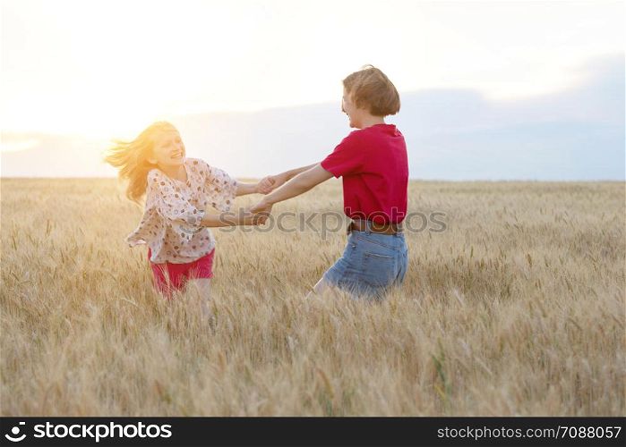 Sister girls having fun in the wheat field